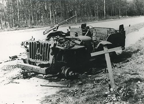 Burnt out Jeep on side of road.