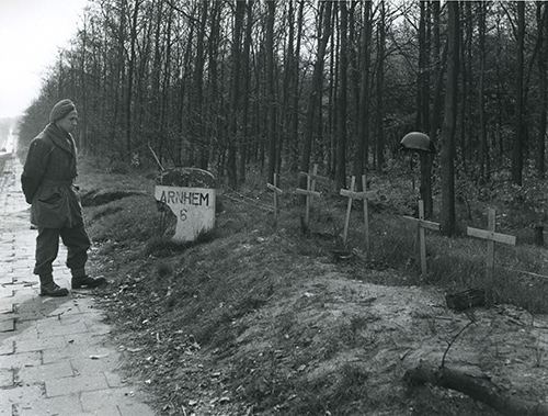 A soldier pauses by temporary graves