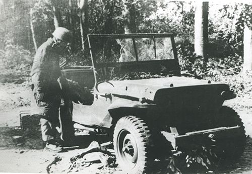 A German soldier inspects a damaged British jeep