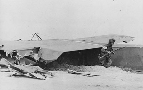 A US soldier rushes from a torn glider