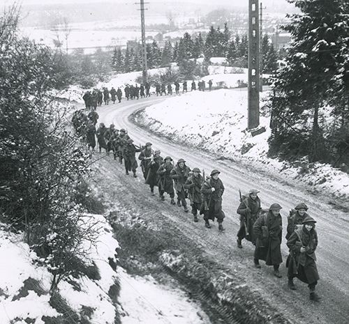 British infantry advancing through the snow in the Ardennes