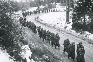 Browse British infantry advancing through the snow in the Ardennes