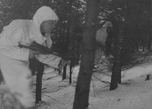 A British Airborne soldier patrols through the woods