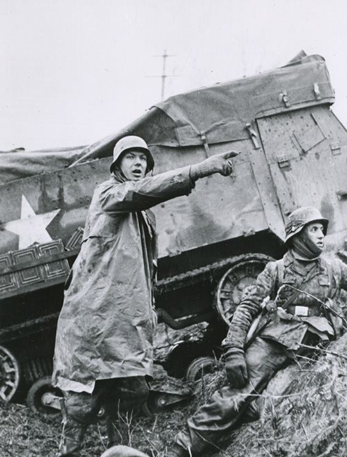 Nazi soldier beside a disabled American half-track