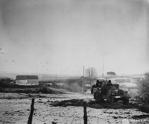 American soldiers stop to watch C-47 transport planes