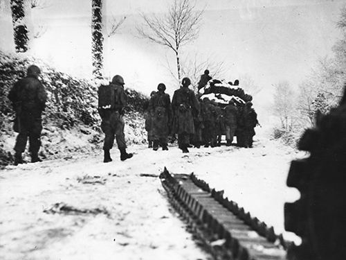 US infantrymen follow a Sherman tank