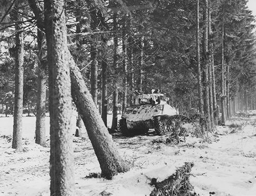 A Sherman moving along a forest road near Bastogne