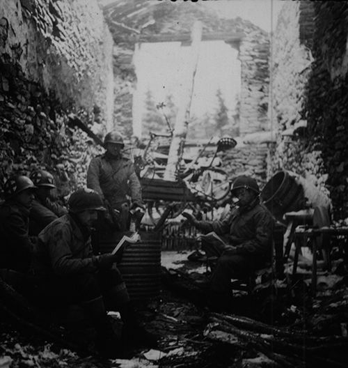 Medics warming up around an oil drum stove