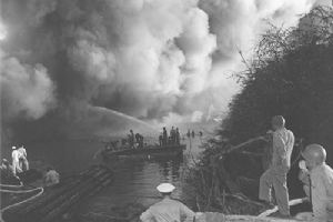 Browse Men watch as fire fighters battle flames in USS LST-480